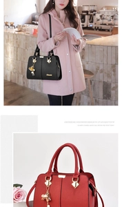 Détail du sac à main en cuir grainé avec pendentif fleur doré et boucle métallique