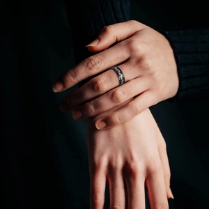 Retro stainless steel ring with black and gold dragon pattern worn on hand by male model