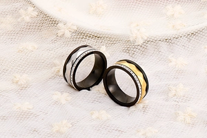 Detailed close-up of faceted black titanium couple rings with sparkling inlay