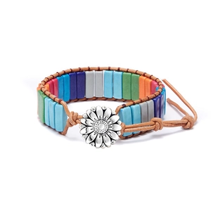Dettaglio di un bracciale boho intrecciato con perline colorate e ciondolo a girasole