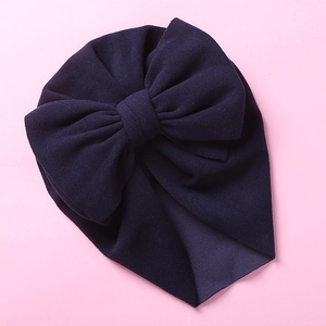 Detail of newborn baby turban hat in deep purple with handmade double bow and soft knit fabric