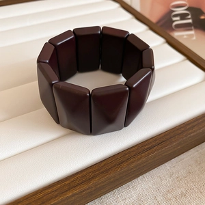 Detailed close-up of dark brown geometric resin blocks on a luxury elastic bracelet