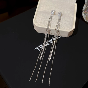 Detail showing long silver tassel earrings with rectangular gemstone on jewelry box