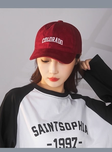 Detailed view of red cotton twill baseball cap with white COLORADO embroidery detail