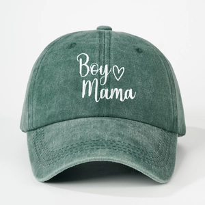 Detail of Boy Mama embroidery and heart on a washed dark green baseball cap texture