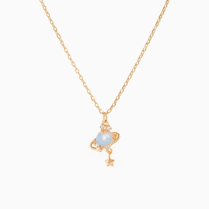 Macro shot of gold Saturn pendant with light blue orb and star charm on cross chain