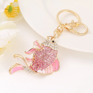 Close-up of golden fish keychain featuring pink enamel and sparkling crystals