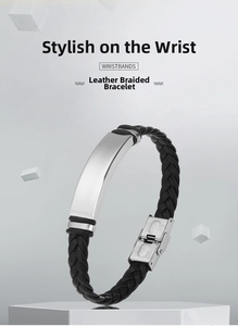 Detail of black braided leather bracelet with engraved stainless steel clasp and charm