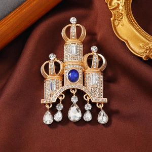 Vintage gold crown brooch with blue stone, crystal fringe, and royal style design