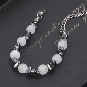 Minimalist beaded bracelet with white cat eye stones and dark grey metallic spacers