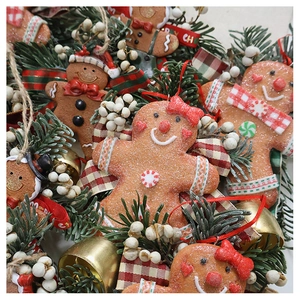 Close-up of Christmas gingerbread man ornament with gold bells and pine needles