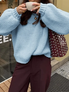 Close-up of women's light blue chunky knit sweater with a relaxed crew neck fit