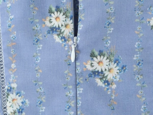 Dettaglio del tessuto a fiori con cerniera invisibile sull'abito blu