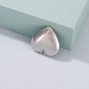 Polished silver stainless steel heart pendant for DIY jewelry on a textured background