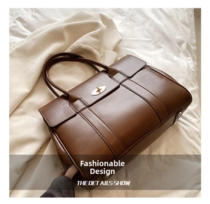 Detail view of large dark brown leather tote bag with vintage golden twist lock closure