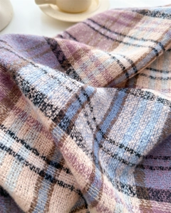 Close-up of soft plaid scarf fabric with pink and blue lines and woven texture details