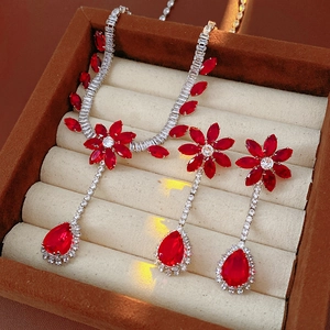 Macro detail of vintage floral teardrop jewelry set with red gemstones in luxury gift box