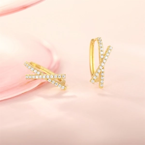 Detailed view of gold-plated X-shape hoop earrings set with sparkling white zircon stones