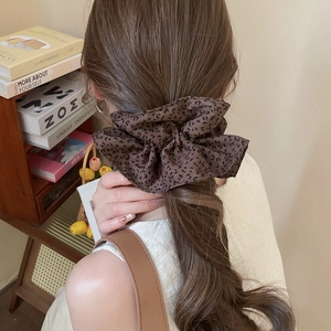 Detail showing oversized leopard print scrunchie on ponytail with chiffon fabric texture