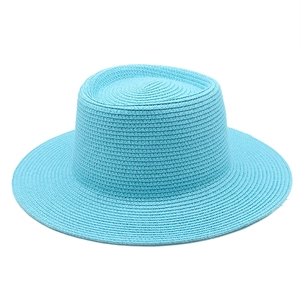 Close-up of the sky blue woven straw sun hat with detailed spiral texture and wide brim