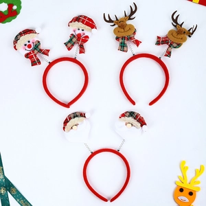 Détail d'un ensemble de trois serre-têtes de Noël lumineux avec de petites peluches festives