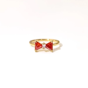 Elegant gold bow ring featuring red triangle zircons and center clear crystal