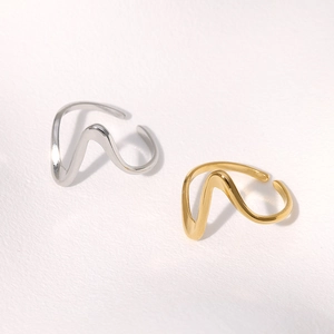 Detailed view of wave-shaped minimalist open rings in gold and silver stainless steel