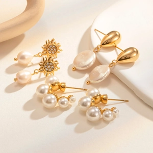 Detail view of French vintage gold earrings set with pearls and zircon in sunlight