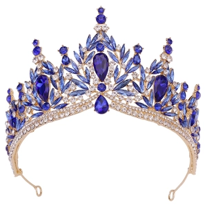 Close-up of bridal crown with gold leaves and blue crystals on white background
