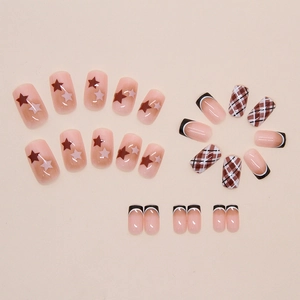 Vue détaillée de faux ongles roses avec motifs d'étoiles, carreaux et pointes french