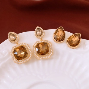 Detail of drop-shaped zircon earrings in champagne brown with elegant metallic finish