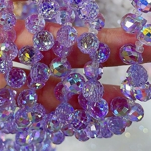 Macro shot of 8mm purple faceted crystal glass beads showing fine light refraction