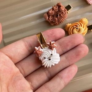 Handmade white puppy cookie hair clip with brown cream and star details on gold metal