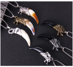 Macro view of vintage wolf tooth necklaces in silver and bronze with detailed dragon design