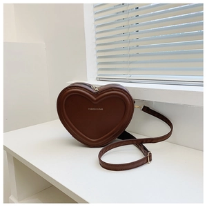 Dettaglio di una borsa a tracolla marrone a cuore con scritte dorate Fashion su pelle PU