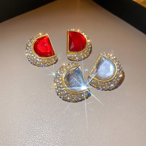 Détail macro de boucles d'oreilles rétro en or avec cristaux rouges et pavé de diamants