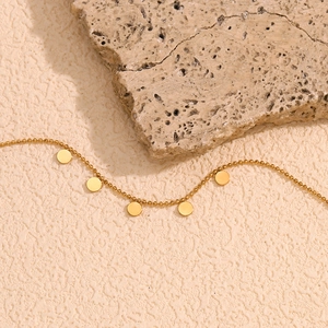 Detail of 18K gold-plated beaded chain bracelet with smooth round discs on textured stone