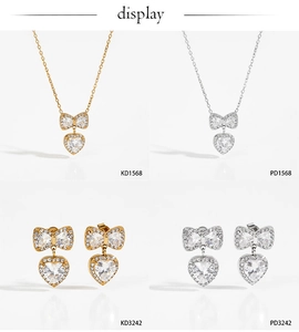Macro shot of stainless steel bow and heart jewelry sets in gold and silver finishes