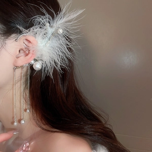 Detailed view of feather and pearl tassel ear cuff earring on model with metallic chains