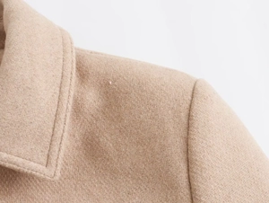 Detail of camel wool blend jacket showing lapel stitching and twill fabric texture