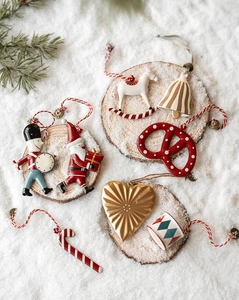 Flat lay of Nordic Christmas tree ornaments like Santa and Nutcracker on snowy background