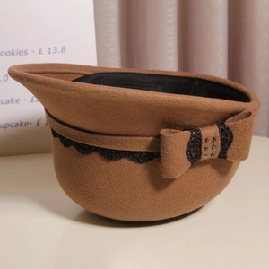 Close-up of brown wool felt equestrian hat with lace trim and beaded bow detail