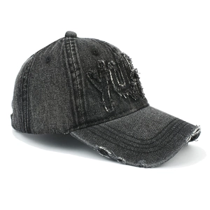 Détail d'une casquette de baseball en denim délavé avec finitions usées et broderie York