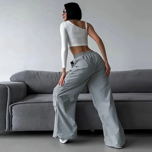 Dettaglio dei pantaloni cargo grigi a gamba larga con coulisse regolabile e vita alta