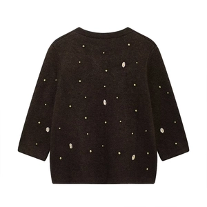 Detail of dark brown knit cardigan with gold pearls and marquise rhinestone decorations