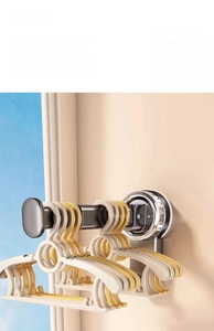 Detail view of wall-mounted suction cup drying rack holding multiple plastic hangers