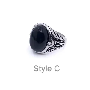 Detail of vintage men's steel ring with black gemstone and engraved side patterns