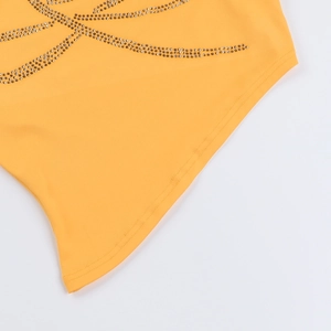 Détail du motif de rose en strass et de l'ourlet sur un haut jaune à col montant