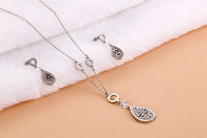 Detailed view of silver leaf jewelry set with zircons and Forever Love engraving