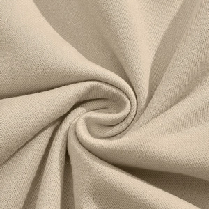 Detailed close-up of light beige corduroy texture showing fine knit fabric fibers and soft folds